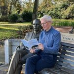 Dr Kenneth McHardy at JJR Macleod Memorial Statue with newly published biography of Macleod